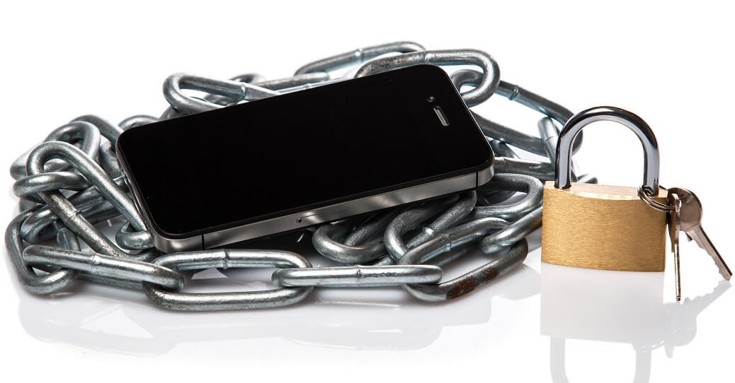 cell phone lying on chain with padlock and keys