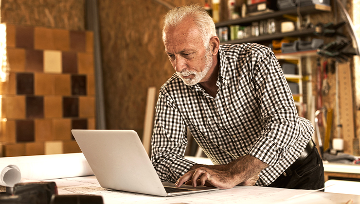older male on computer in a workshop