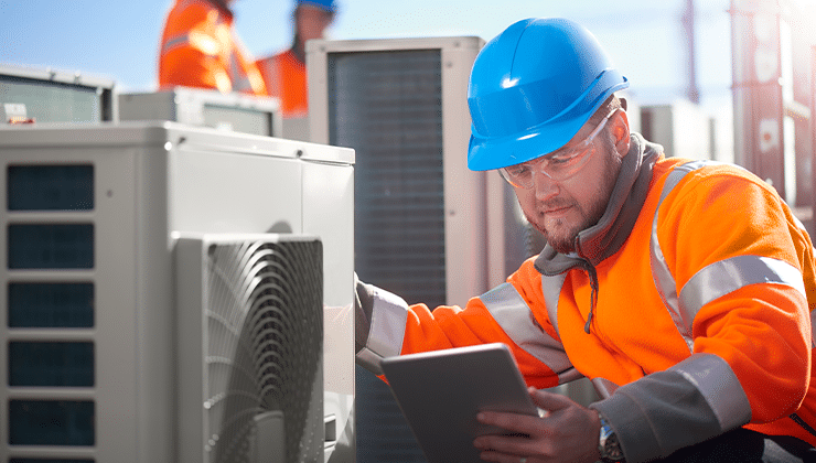 male hvac technician on job site with tablet